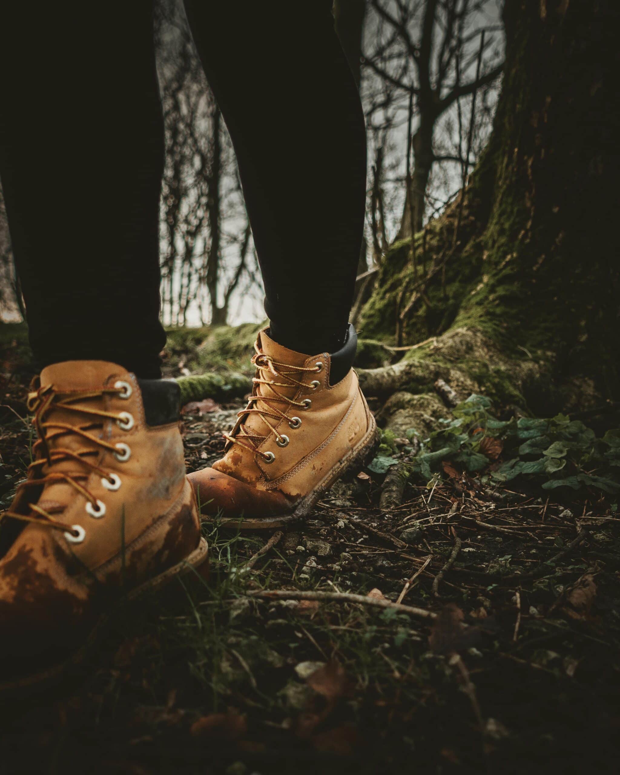 Close-up of hiking boots on a forest path during a nature walk.